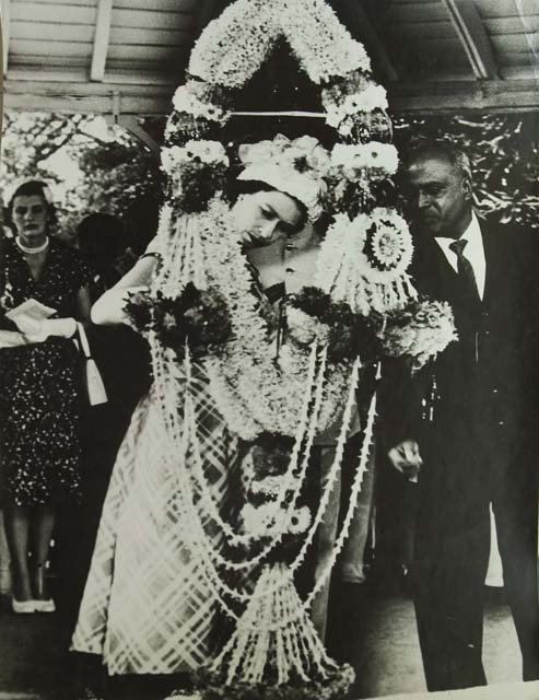 Homai Vyarawalla, Indian (1913 – 2012) Queen Elizabeth II examining a gigantic garland presented to her in Madras; 1961 Gelatin Silver Print Alkazi Collection of Photography