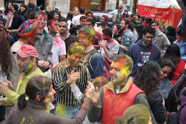 Revelers douse each other with colored powders for Holi