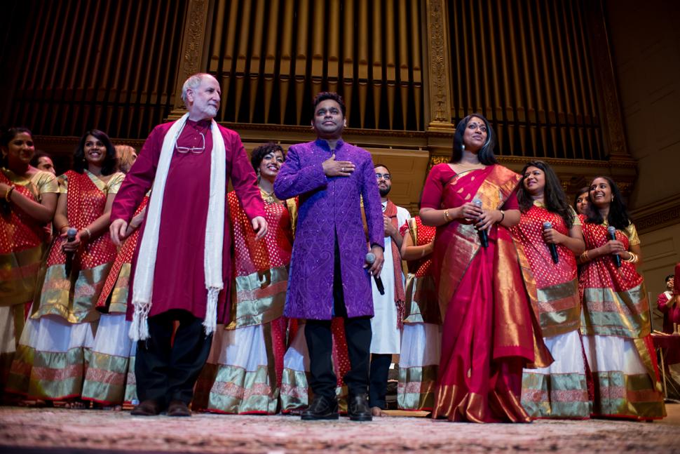 Faculty members Eugene Friesen and Annette Philip flank A.R. Rahman during final bows at the end of the October 24 concert. Performers from the Berklee Indian Ensemble stand in the back row.