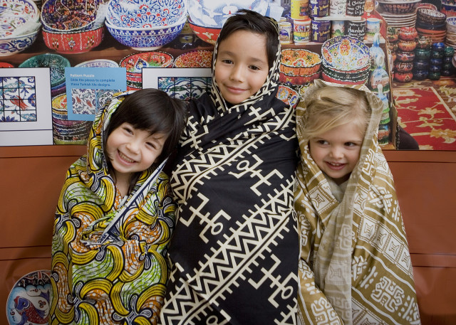 Children experience the fabrics designed by Muslim artisans