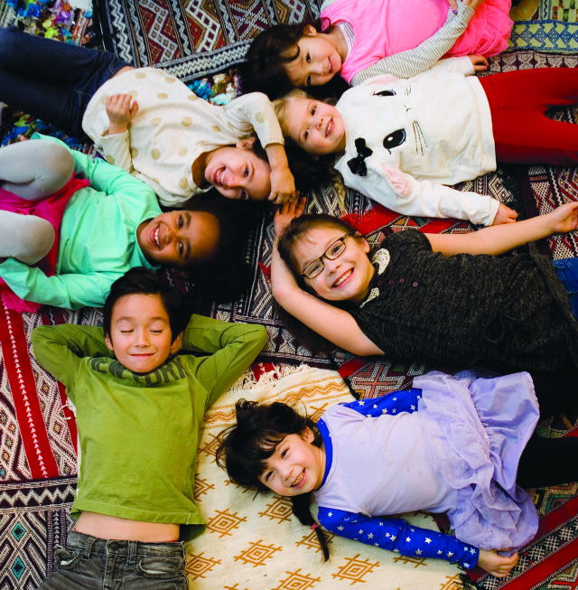 Children try out the rugs created by Muslim artisans