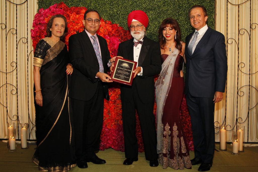 Dr. Manjit Singh Bains receives the award from CG Chakravorty and Dina Pahlajani, AJ and Poonam khubani.